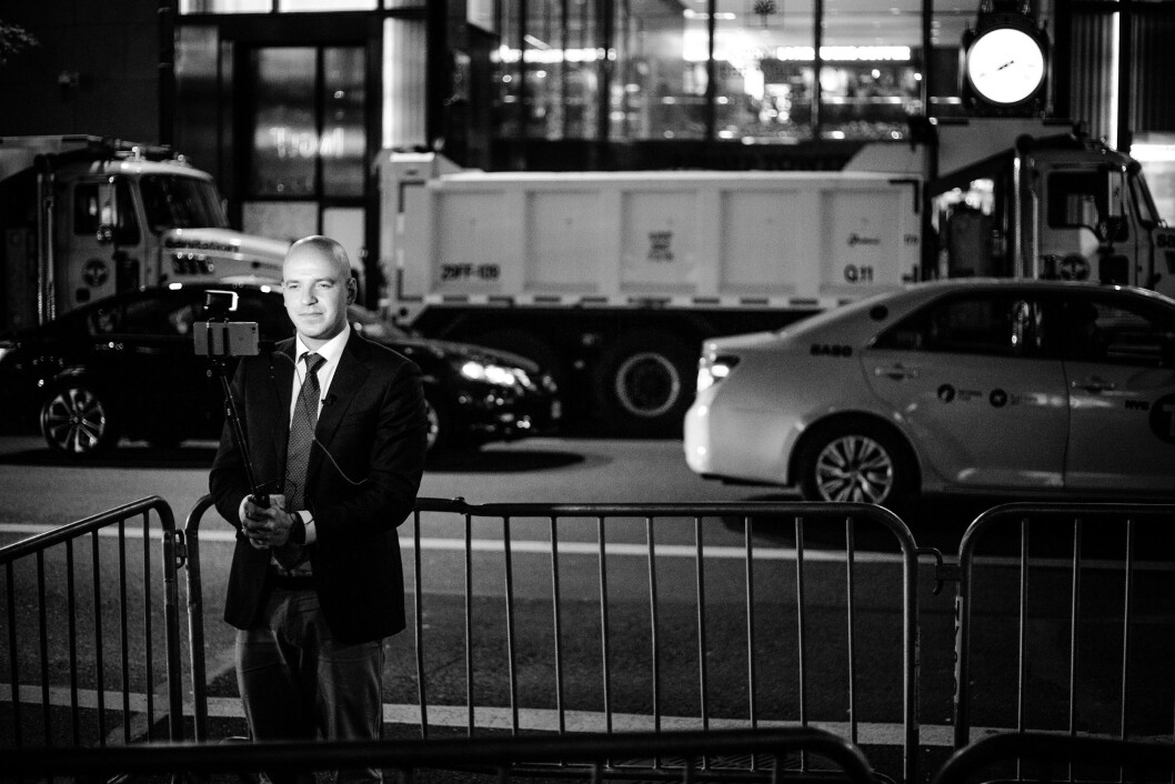 TRUMP TOWER, 8. NOVEMBER 2016 - KL 19.37: Utenfor Trump Tower, noen få kvartaler fra valgvaken, så sto en enslig reporter med selfiestang og mobilkamera inngjerdet i pressepiten. I bakgrunnen ser vi lastebiler fylt med sand, for å beskytte mot eventuelle angrep. De første meldingene om at Trump faktisk kunne vinne Florida begynte å komme inn. TRUMP TOWER, 8. NOVEMBER 2016 - KL 19.37: Utenfor Trump Tower, noen få kvartaler fra valgvaken, så sto en enslig reporter med selfiestang og mobilkamera inngjerdet i pressepiten. I bakgrunnen ser vi lastebiler fylt med sand, for å beskytte mot eventuelle angrep. De første meldingene om at Trump faktisk kunne vinne Florida begynte å komme inn.