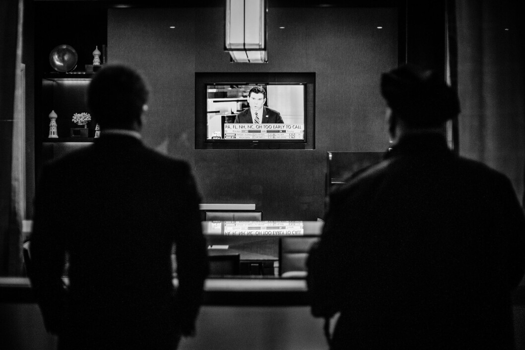 HILTON MIDTOWN, 8. NOVEMBER 2016 - KL 20.37: En mann jeg tror er Secret Service-agent og en mann jeg er bra sikker er politimann ser på Fox News på en TV-skjerm inne på Midtown Hilton. Det er for tidlig å kåre en vinner i de fleste vippestater, men Donald Trump gjør det bedre enn forventet. HILTON MIDTOWN, 8. NOVEMBER 2016 - KL 20.37: En mann jeg tror er Secret Service-agent og en mann jeg er bra sikker er politimann ser på Fox News på en TV-skjerm inne på Midtown Hilton. Det er for tidlig å kåre en vinner i de fleste vippestater, men Donald Trump gjør det bedre enn forventet.