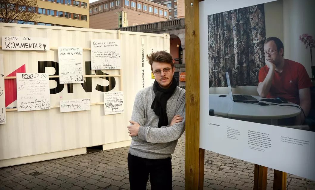 Fotograf Kyrre Lien sammen med sin utstilling på Youngstorget i Oslo.