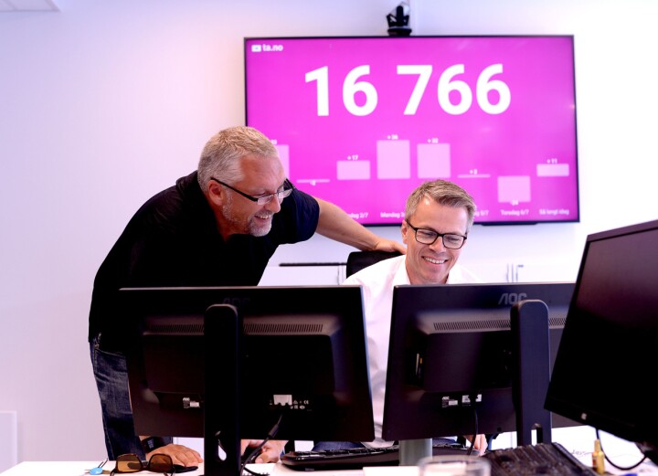 Ofte sett: Amedia-ledere foran rosa vegg med stort tall. Det forteller hvor mange som har registrert seg med aID på TA.no.