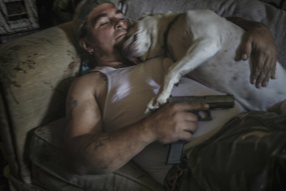 Lederen av militsgruppen My Brothers Threepers, Danny Bollinger (43), på sofaen i stua i Maryland. Han har flere titalls våpen spredd rundt i huset og øver hver dag i hagen.