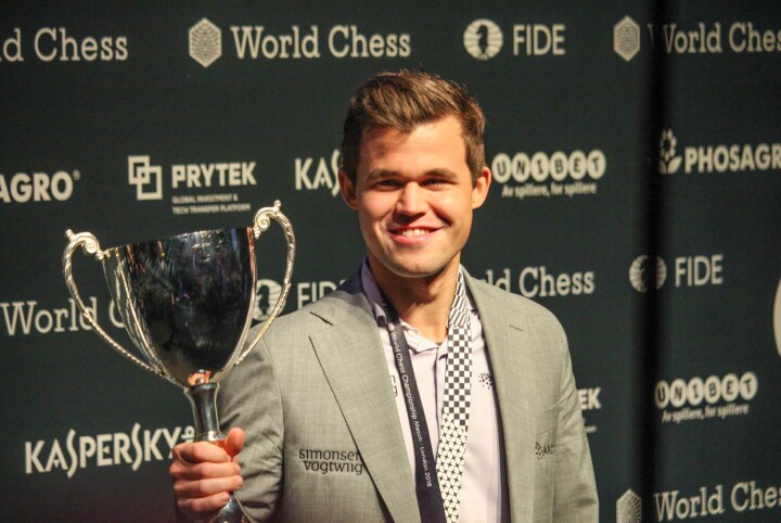 Magnus Carlsen med vinnerpokalen etter seier i sjakk-VM 18. november 2018.