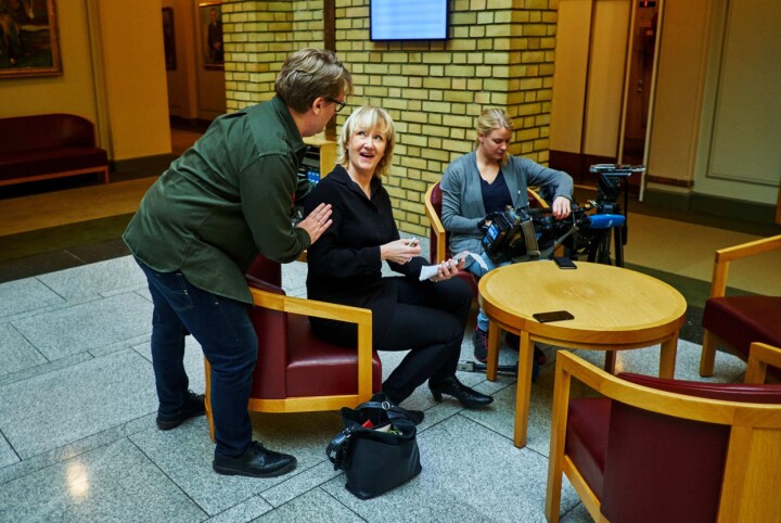 Eirik Mosveen hilser på NRKs Lisbeth Skei i vandrehallen på Stortinget.