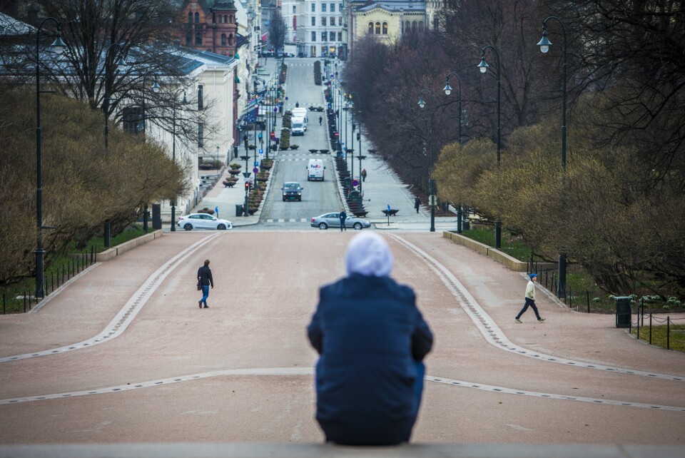 Koronaviruset setter sitt preg på Norge. Tirsdag forrige uke var det svært få mennesker ute i Oslo sentrum. En mann sitter i trappen foran Slottet og skuer ut overr et nesten folketomt Karl Johan.