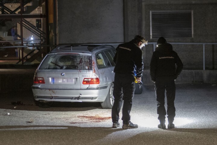 Kriminalteknikere fra politiet undersøker området rundt en bil parkert ved stedet der flere personer ble skadd i et masseslagsmål utenfor Lyngdalshallen tirsdag kveld.
