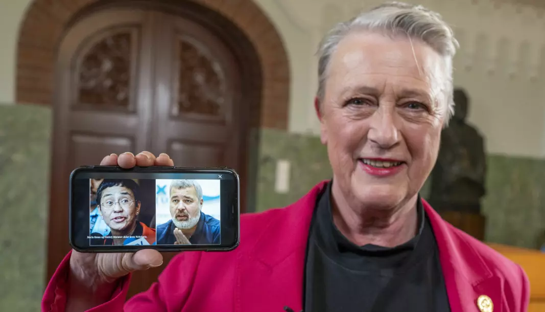 Berit Reiss-Andersen, leder av Nobelkomiteen, viser frem et bilde på en mobiltelefon av årets fredsprisvinnere, journalistene Maria Ressa og Dmitrij Muratov på Nobelinstituttet i Oslo fredag.