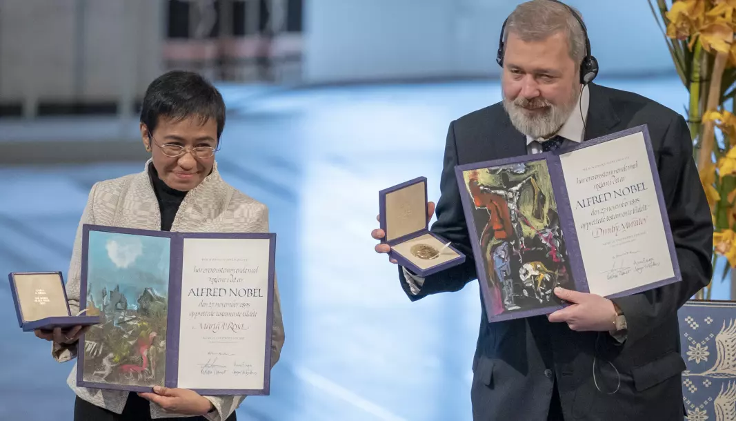Fredsprisvinnerne Maria Ressa og Dmitrij Muratov avbildet med hver sin gullmedalje og diplom under utdelingen av Nobels fredspris i Oslo rådhus høsten 2021.