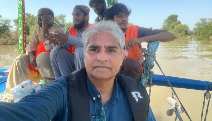 Atta Ansari avbildet på vei til en landsby som er helt omringet av elven Indus. Beboerne er helt isolerte på en «øy», forteller han.