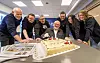 Gruppebilde av kollegaer ved en kake