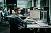 mann som sitter ved kontorplassen sin foran skjerm