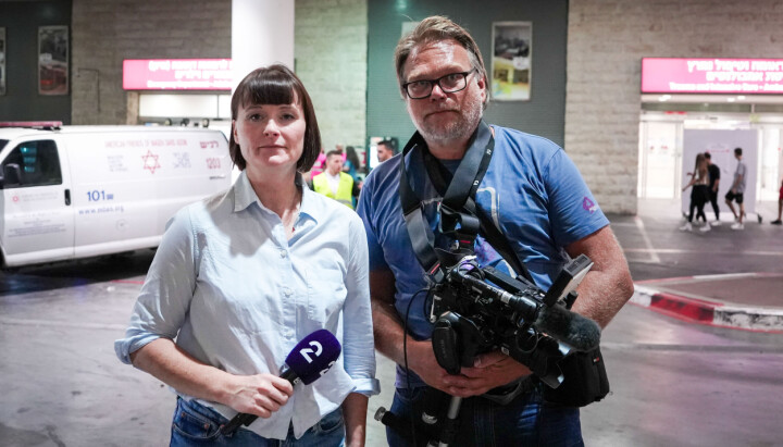 TV 2s utenriksreporter Hilde Gran og fotograf Aage Aune avbildet i Israel. En kvinne med mikrofon og en mann med kamera på gaten foran en bygning.