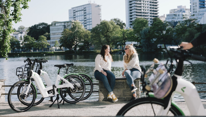 Kolumbus søker markedsrådgiver - Ny mobilitet bybilde. To som snakker sammen med sykler rundt seg