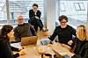kolleger som snakker sammen på møterom