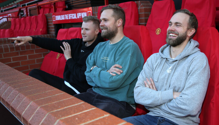 Fredrik N. Filtvedt (fra venstre), Jon Martin Henriksen og Eivind B. Holth har blant annet besøkt Old Trafford med podkasten. Her tester de ut innbytterbenken.