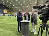 ansatte i intervju foran fotballbane