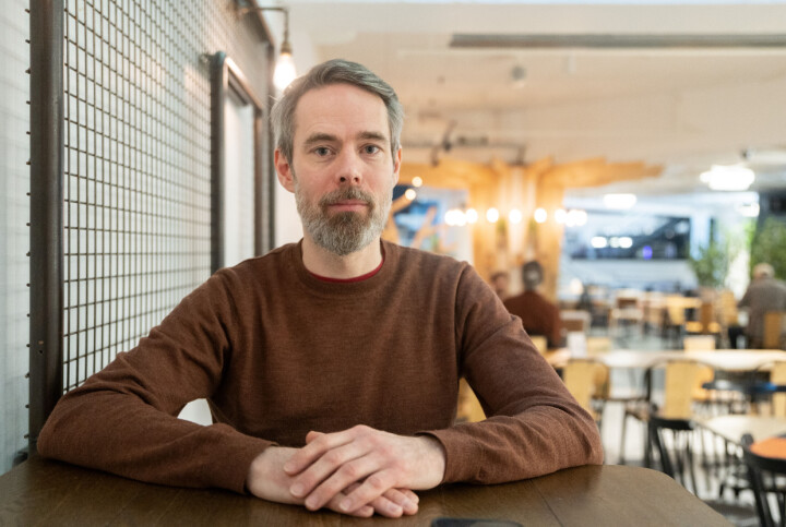 Erik Fossen, klubbleder i Bergens Tidende. Mann med skjegg ser inn i kamera mens han sitter.