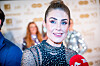 Tone Damli Aaberge smiler foran en sponsorvegg, iført en glitrende svart topp.