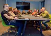 Gruppebilde av kollegaer som sitter sammen ved bordet i et møterom