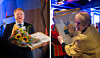 To personer holder innrammede portretter og blomster ved en prisutdeling innendørs.